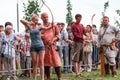 Archery training, master helping young woman in correct posture